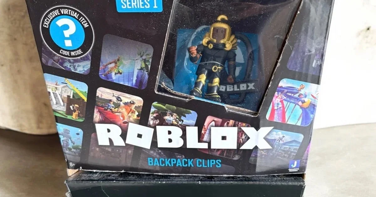 Authentic Roblox Series 1 backpack clips featuring characters such as Dominus Aureus Dude, Builderman, Jailbreak: Inmate, Mr. Robot, and Adopt Me!: Holly. These plastic figures are black, gold, orange, and grey. Each clip includes a virtual item code. The lot includes one loose figure and four figures in their original plastic packaging within a display box.
